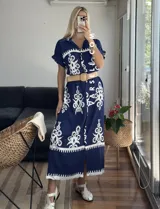 Vestido camisero largo negro con estampado de flores blancas y cinto incluido.