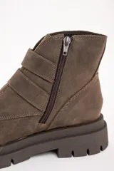 Botas cortas de cuero color visón con suela track, cierre lateral y doble tira con hebillas doradas.