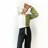 Blusa de mangas largas, con corte holgado y escote redondo. Presenta un diseño color block, con la mitad izquierda en color blanco y la mitad derecha en color verde oliva.