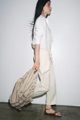 Pantalón jogger wide leg color crudo, confeccionado en hilatura con lino. Tiro medio, cintura elástica ajustable con cordones, bolsillos laterales ocultos en costura y pierna ancha.
