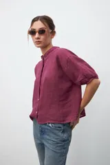 Camisa de lino color borgoña con cuello mao, manga corta abullonada y cierre frontal con botones. Corte holgado.