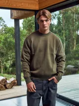 Sweater de punto color verde militar, de manga larga y cuello redondo.