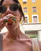 Collar artesanal con dije de flor plateada, realizado con hilo de seda natural teñido a mano.