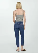 Pantalón de jean azul oscuro, tiro alto, corte mom fit, con cinco bolsillos y cierre de cremallera y botón.