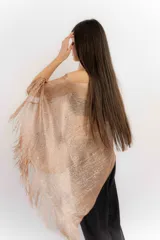 Poncho tejido color cobre con apliques de piedras y flecos.