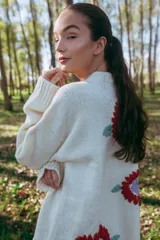 Maxi cardigan color crema de lana merino con bordado de flores rojas y azules.