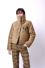 Campera corta color beige de tela texturizada, con cierre frontal por botones a presión, bolsillos delanteros, cuello alto y bordado negro con el logo CP en el pecho. Tiene forro interior y relleno liviano de guata.
