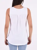 Camisa blanca sin mangas con cuello en V y cierre frontal con botones.