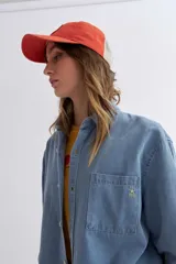 Camisa celeste de jean de manga larga con cuello clásico y cierre frontal con botones.