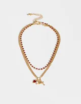 Set de dos collares dorados con cadenas de diferentes diseños. Uno con strass rojos y otro con dijes de corazón, perla y cruz.