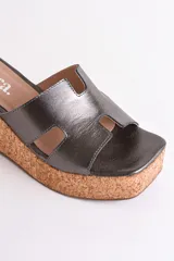 Sandalia dorada con plataforma de corcho y tiras cruzadas.