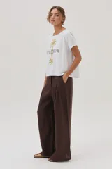 Remera blanca de algodón con estampa de palmeras y la palabra "Sunrise" en el frente.