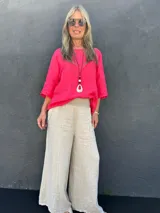 Pantalón palazzo de lino color beige, con cintura elastizada, bolsillos laterales y presillas para cinturón.