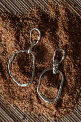 Aros colgantes plateados con forma irregular.