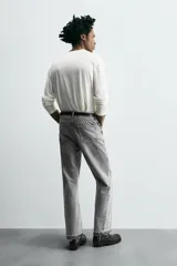 Pantalón de jean celeste de corte flare, con cinco bolsillos, efecto lavado y bajo con acabado irregular.