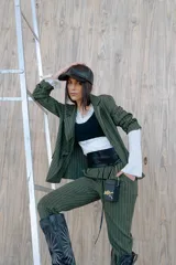 Blazer verde con rayas verticales blancas, solapas clásicas y corte entallado.