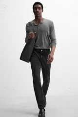 Pantalón de jean azul oscuro, corte slim fit, tiro medio, cinco bolsillos, tejido elástico y efecto lavado.
