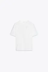 Camiseta blanca de cuello redondo y manga corta con detalle de flores con volumen en delantero a tono.