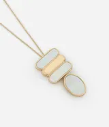 Collar largo con cadena dorada y dije geométrico con formas rectangulares y ovaladas en nácar y dorado.