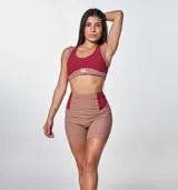 Conjunto deportivo marrón con detalles en color borgoña, compuesto por un top deportivo con logo "bk." y unos shorts de ciclista de tiro alto.