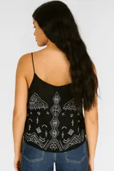 Musculosa negra de breteles finos con escote en V y bordado blanco con motivos geométricos.