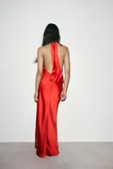 Vestido largo rojo de satén con cuello halter y espalda descubierta. Cierre trasero con cremallera oculta y lazo.