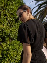 Top marrón con lunares blancos, escote en V, mangas cortas amplias y lazo central.