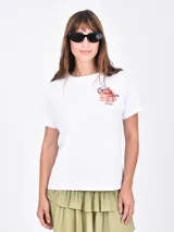 Remera blanca de manga corta con cuello redondo y un pequeño estampado frontal de una pila de panqueques con fresas y el texto "Sweet Stacks".