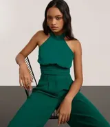 Blusa cropped marrón con escote halter, cuello alto con cierre en el cuello y pliegues en la cintura.