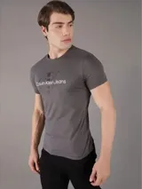 Remera gris de manga corta con cuello redondo y logo de Calvin Klein Jeans estampado en el frente.