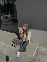 Pantalón palazzo negro con lunares blancos, confeccionado en viscosa.