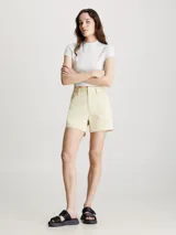Shorts color crema de sarga de algodón elástica, talle alto, con bragueta con cremallera, diseño de cinco bolsillos, acabado ligeramente lavado y herrajes de Calvin Klein.