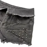 Short de jean negro con tachas y detalle de cordones cruzados en el lateral izquierdo.