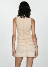 Minifalda beige de tiro bajo con cinturón y hebilla metálica, confeccionada en tejido denim de algodón.