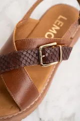 Sandalias marrones con tiras cruzadas de cuero liso y cuero con textura de reptil.