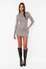 Vestido corto gris de tejido de punto satinado con cuello semipolera, mangas largas con mitones en los puños y espalda descubierta con elástico.