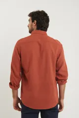Camisa azul marino de lino y algodón, con cuello abotonado, manga larga con puños enrollados, bolsillo de parche en el pecho y cierre frontal con botones.