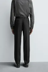 Pantalón de vestir negro de lana, corte recto, con bolsillos laterales y traseros de ojal con botón.
