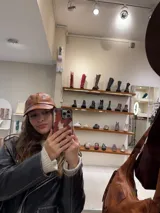 Gorra marrón de cuero con visera y ajuste trasero.