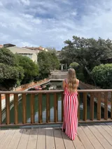 Falda larga tejida a rayas rojas y blancas, con pretina elástica y tajos laterales profundos.