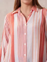 Camisa color beige claro, de corte recto y mangas 3/4 con botón para sujetar.