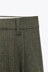 Pantalón de tiro alto color verde oliva, con pinzas delanteras, bolsillos laterales y falsos bolsillos traseros con solapa. Cierre frontal con cremallera y ganchos metálicos.