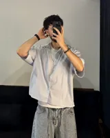 Camisa celeste y blanca a rayas verticales, de corte boxy fit y manga corta.