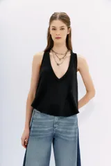 Musculosa blanca de algodón flameado, con escote en V pronunciado y espalda deportiva.