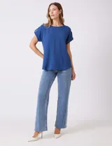 Blusa azul de crepe, marca Ninety Clothing, con cuello a la base y manga corta con presilla y botón.