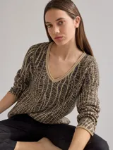 Buzo de punto color beige con diseño geométrico en negro. Incluye cuello alto y falda cruzada a juego.