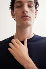 Remera negra de corte ajustado en punto suave de algodón pima, con cuello redondo ribeteado acanalado fino y bajo recto.