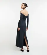 Vestido midi de jersey negro, con escote hombro a hombro, mangas largas, aberturas en el busto y tajo en la espalda.