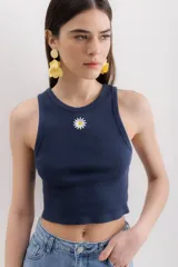 Musculosa gris jaspeado con cuello redondo y bordado de una margarita en el centro.
