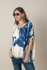 Blusa italiana color natural con estampado de hojas en tonos azules. De calce holgado y talle único.